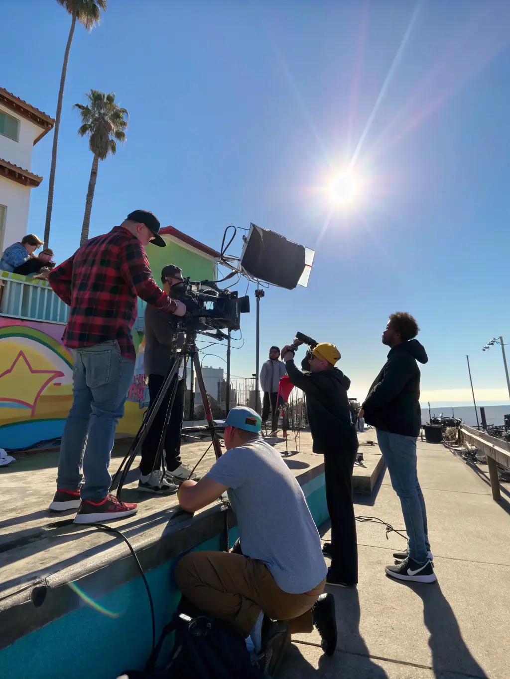 A still from a short film produced during a La Fabrique Imaginaire cinema workshop, featuring young filmmakers behind the camera and actors performing a scene.