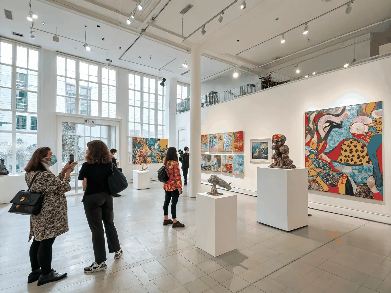 A vibrant display of artwork created during a visual arts exhibition, featuring paintings, sculptures, and mixed media pieces, with visitors admiring the diverse artistic expressions.